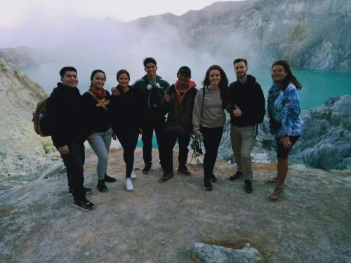 a group of people standing in front of a waterfall at jala sutra cottages in Giri