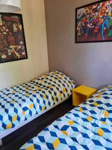 Cette chambre comprend 2 lits et une photo murale. dans l'établissement Bel appartement tout proche du Mont st Michel, à Pontorson