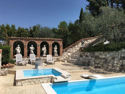 a swimming pool in a yard with a stone wall at Isola Verde in Durazzano