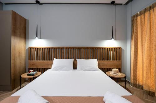 a bedroom with a large white bed and two tables at Galaxy Hotel in Porto Heli