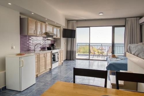 a kitchen and dining room with a view of the ocean at Hersonissos Harbour View in Hersonissos