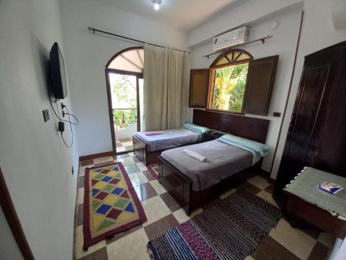 a living room with two beds and a window at BAYT ZAINA - Nubian hospitality house in Aswan