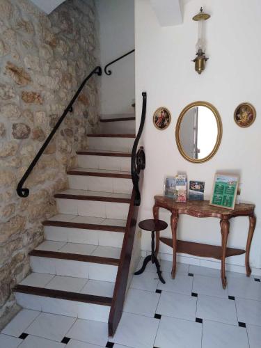 - un escalier dans une pièce avec une table et un miroir dans l'établissement Gite des ARTS, à Saint-Geniès-des-Mourgues