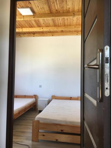 a door leading into a room with two beds at Domki Snopki in Pisz