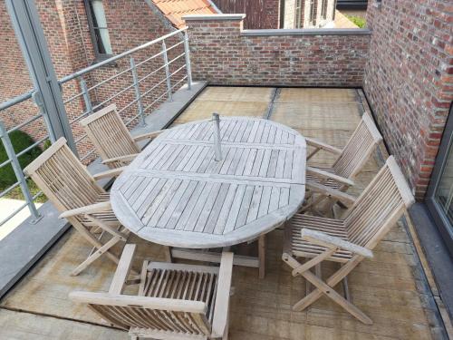 a wooden table and chairs on a patio at Vakantiewoning Op Den Briel in Lokeren