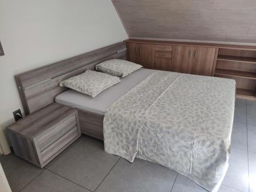 Dormitorio pequeño con cama y armarios de madera en Vakantiewoning Op Den Briel en Lokeren