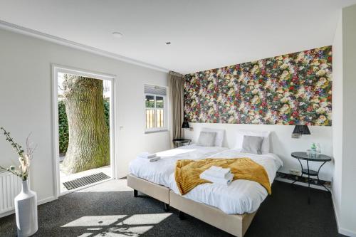 a bedroom with a large bed with a floral wall mural at Herberg de Loohoeve in Schoonloo