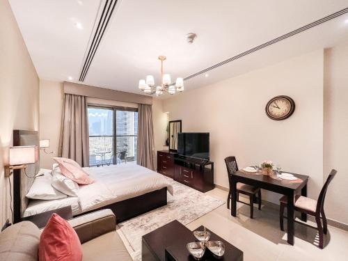 um quarto com uma cama e uma sala de estar em Luton Vacation Homes - Elite Residence Downtown, Burj Khalifa View, Dubai em Dubai