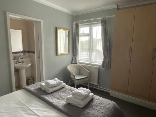 a bedroom with two towels sitting on a bed at The Paddocks Hotel in Symonds Yat