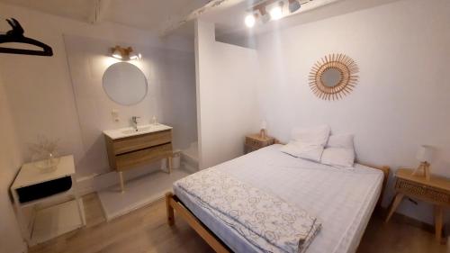 sypialnia z łóżkiem, umywalką i lustrem w obiekcie L Arancio - Centre village - Piscine - 4 pers w mieście Bessan