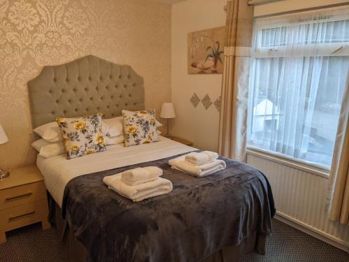 a bedroom with a bed with towels on it at The Paddocks Hotel in Symonds Yat