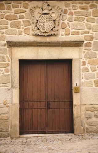 a wooden door on the side of a stone building at CASA GRANDE DE JUNCAIS - SERRA DA ESTRELA in Fornos de Algodres