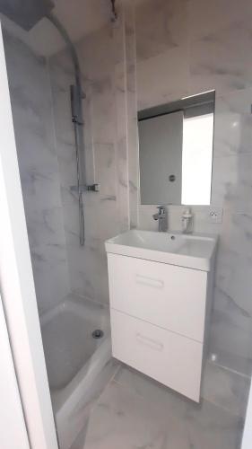 une salle de bain blanche avec un lavabo et une baignoire dans l'établissement Le Soleya - Centre village - Piscine - 2 pers, à Bessan
