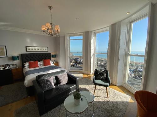 a bedroom with a bed and a couch and windows at A Room With A View in Brighton & Hove