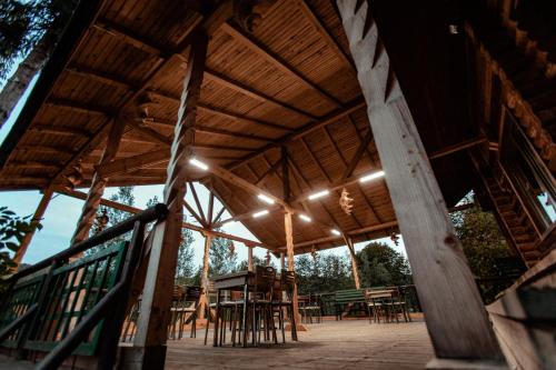 a large wooden pavilion with tables and stools at Cabana La Panţiru in Văleni-Stînişoara