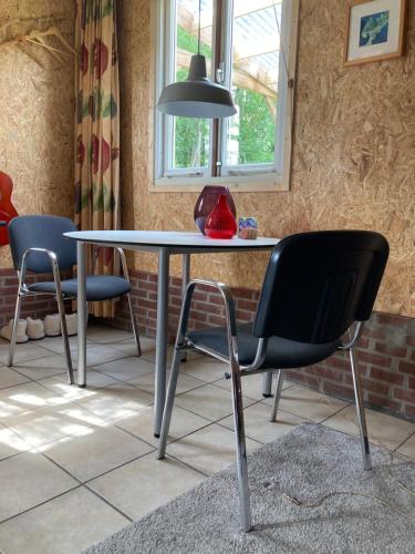 a table with a chair and a lamp in a room at Vakantiehuisje De Waddenuil in Usquert
