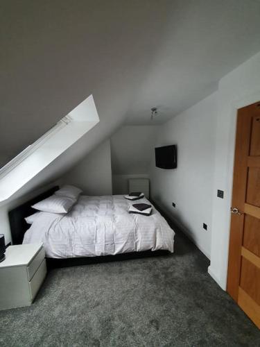 a bedroom with a white bed with a sloped ceiling at Fort William Lovely Flat Central location in Fort William