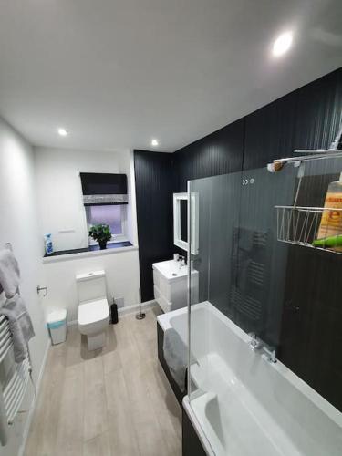 a bathroom with a tub and a toilet and a sink at Fort William Lovely Flat Central location in Fort William