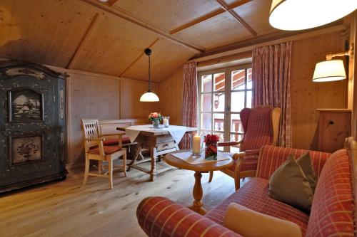 a living room with a couch and a table at Hotel Maier zum Kirschner in Rottach-Egern