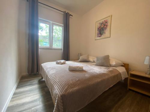 um quarto com uma cama e uma janela em Apartman Ana em Dobropoljana