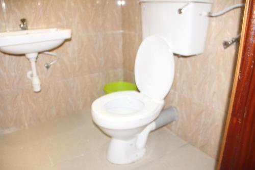 ein Badezimmer mit einem weißen WC und einem Waschbecken in der Unterkunft Snow Valley Cottages in Kasese