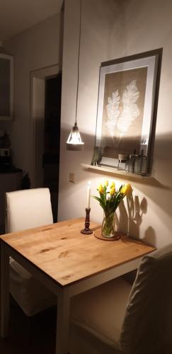 a wooden table with a candle and flowers on it at Ferienwohnung Jeannette I in Hasselfelde