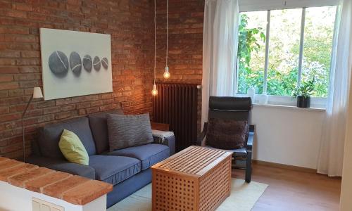 a living room with a blue couch and a brick wall at Ferienwohnung Jeannette I in Hasselfelde