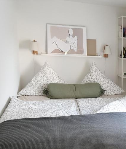 a white bedroom with a bed with pillows at Ferienwohnung Heusler in Hasselfelde