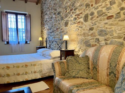 a bedroom with two beds and a stone wall at Casina di Rosa in Civitella Marittima