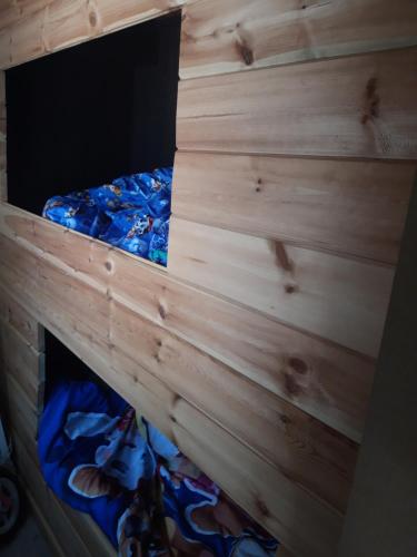 łóżko w pokoju z drewnianą ścianą w obiekcie Vakantiehuisje w mieście Lanaken