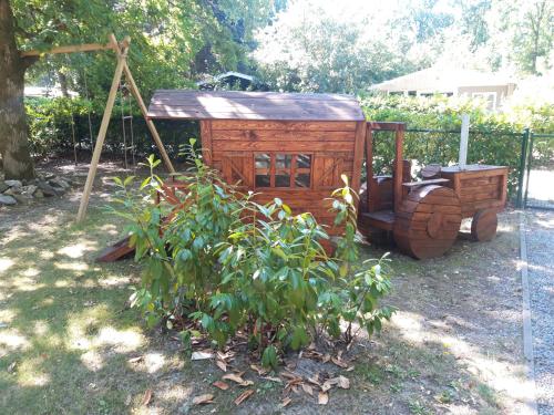 un carrello di legno seduto in un cortile accanto a un albero di Vakantiehuisje a Lanaken