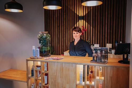 a woman sitting at a counter in a salon at Le Domaine de Baulieu, Singuliers Hotels in Auch