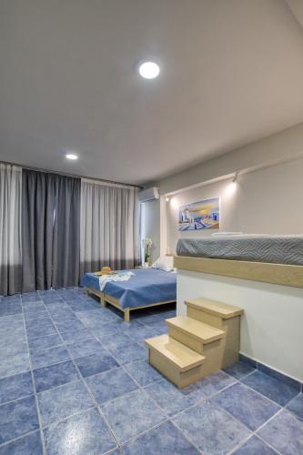 a bedroom with two beds and a blue tile floor at Hersonissos Harbour View in Hersonissos