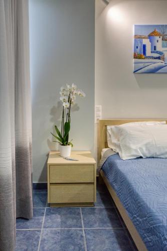 a bedroom with a bed and a table with a plant on it at Hersonissos Harbour View in Hersonissos