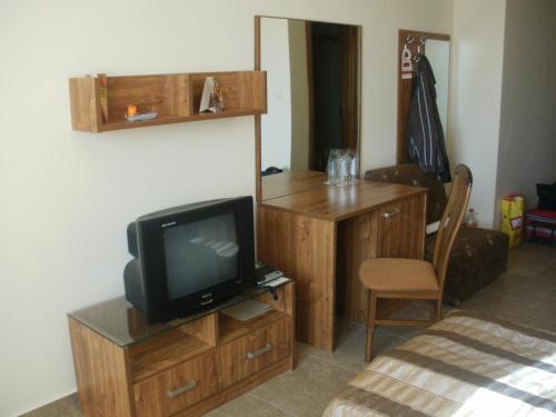a room with a tv and a desk with a chair at Deluxe Room in Stoykite in Pamporovo