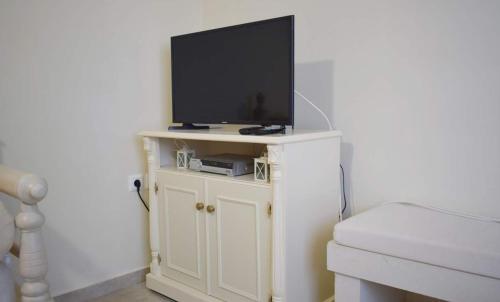 a flat screen tv on top of a white cabinet at Villa Helidoni in Pondikianá