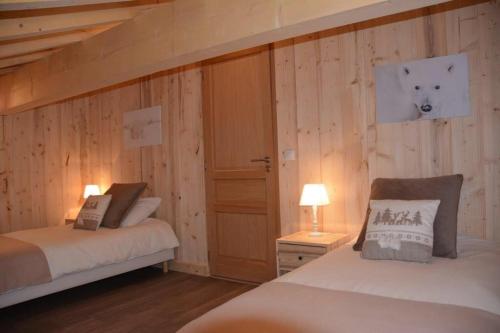 - 2 lits dans une chambre dotée de murs en bois dans l'établissement Chalet Alexanne - Meublé de tourisme classé 3 étoiles - Porte de St Gervais, à Passy