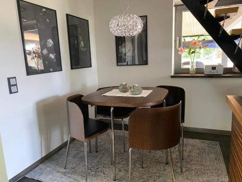 a dining room table with chairs and a chandelier at Atelier Tiedemann in Soltau