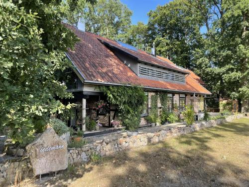 an old stone building with a rusty roof at Atelier Tiedemann in Soltau