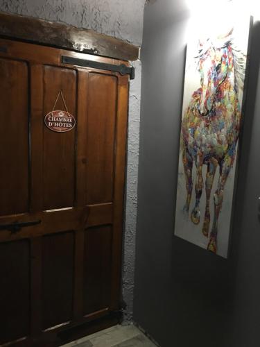 a painting of a horse on a wall next to a door at Véloce, Chambre d'Hôtes avec Salle de Bain / WC in Claveyson