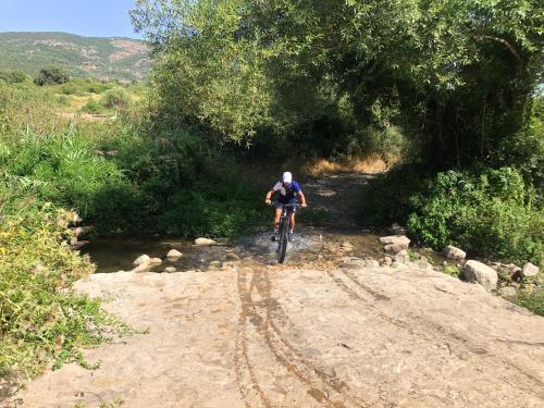 a man riding a bike down a dirt road at Andrebyke in Gergei