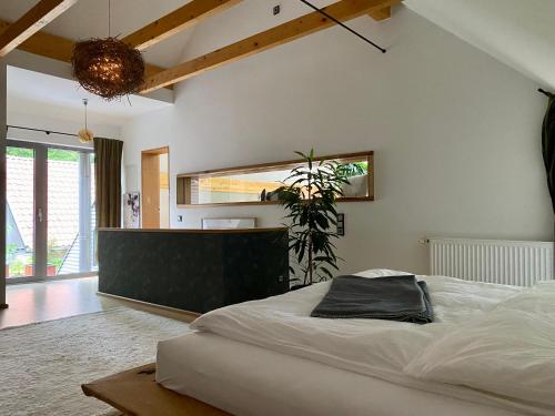 ein Schlafzimmer mit einem großen Bett und einer Pflanze in der Unterkunft Atelier Tiedemann in Soltau