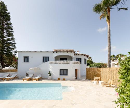 a villa with a swimming pool and a house at CASA LUZ - Somewhere south villas by Astrid Elisee in Benitachell