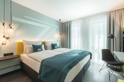 um quarto de hotel com uma cama grande e uma secretária em the niu Seven em Düsseldorf