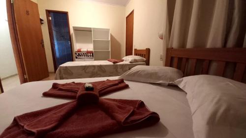 two beds in a room with a robe on the bed at Pousada Girar do Sol in Nova Friburgo