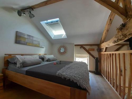 une chambre avec un grand lit avec une lucarne dans l'établissement LPC Dordogne Holidays - Le Petit Coin, à Lussas-et-Nontronneau