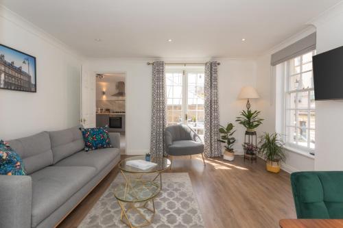a living room with a couch and a table at Crescent Mews in Bath