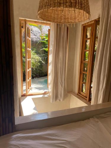 a bedroom with a bed and a window with a view at La Cabane in Jimbaran
