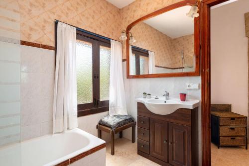 a bathroom with a tub and a sink and a mirror at Villa Lucas - Pollença in Pollença