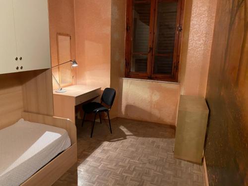 1 dormitorio con escritorio, 1 cama y 1 silla en ViviSiena, en Siena